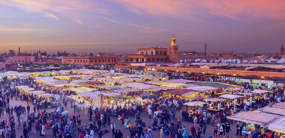 Crowded Jemaa el-Fnaa market square in Marrakech at sunset