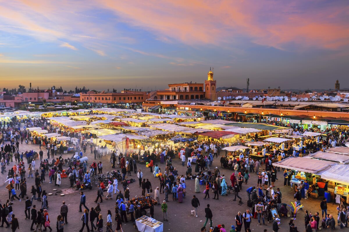 Crowded Jemaa el-Fnaa market square in Marrakech at sunset