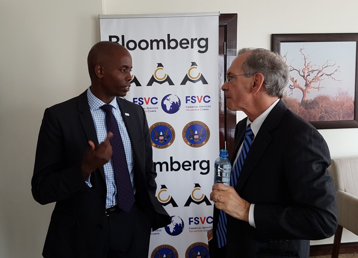 Two professionals engaged in conversation at an event with Bloomberg and Financial Services Volunteer Corps branding